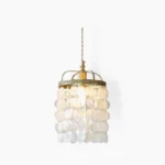 Capiz shell pendant light with natural mother-of-pearl shells suspended in brass frame against white background