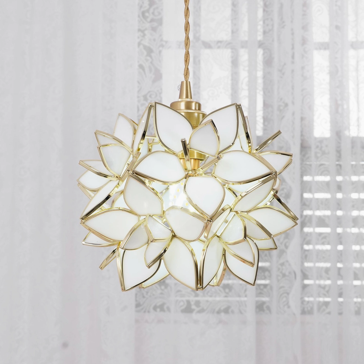 Close-up of Capiz white flower pendant showing sculptural petal arrangement and brass ceiling canopy detail