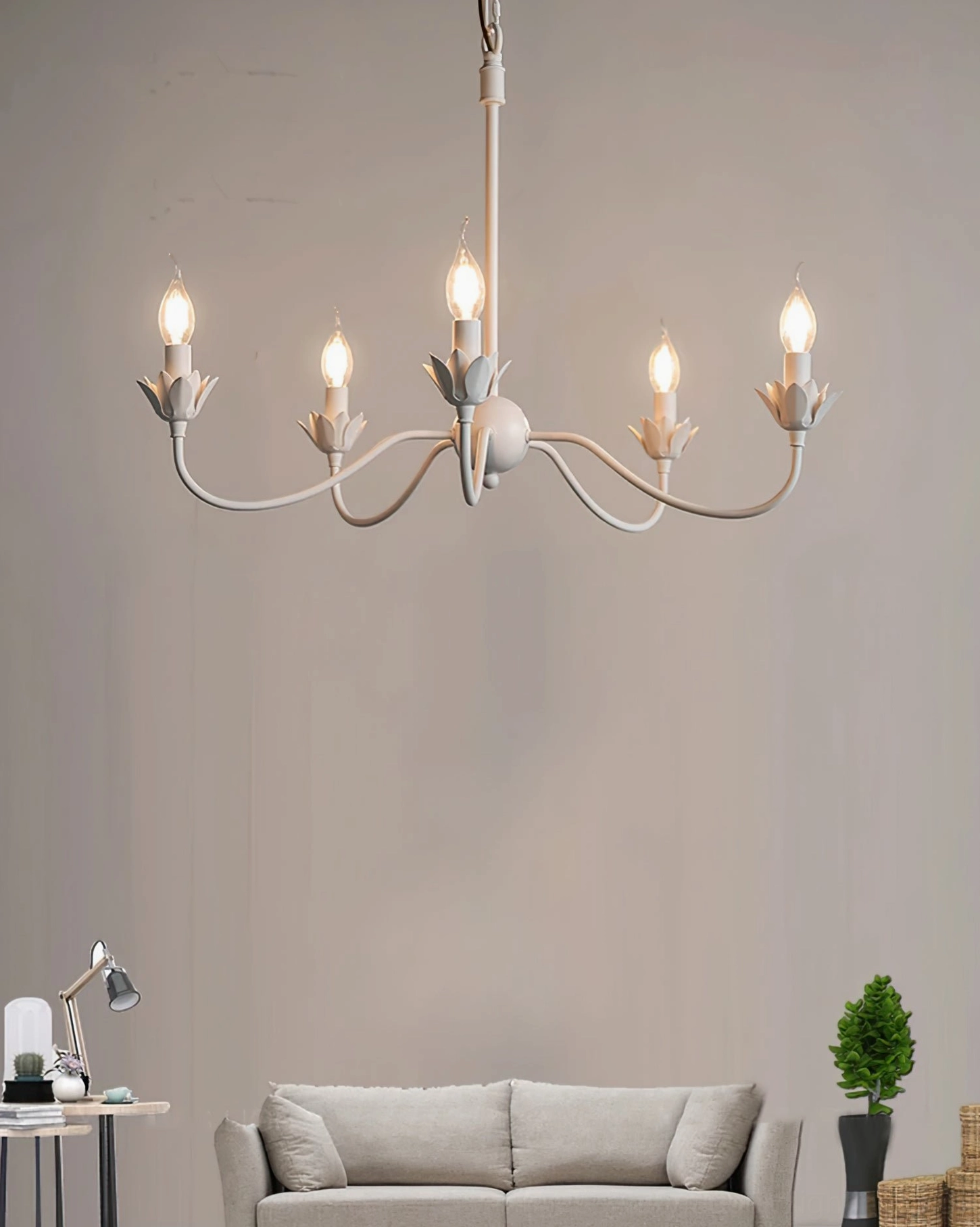 Lit Caposile 5-light white chandelier in cozy farmhouse living room with sofa
