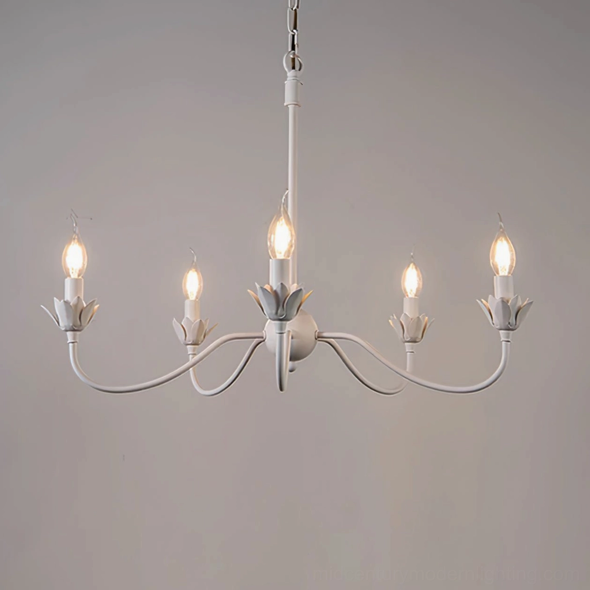 Lit Caposile 5-light white candle chandelier with curved metal arms front view