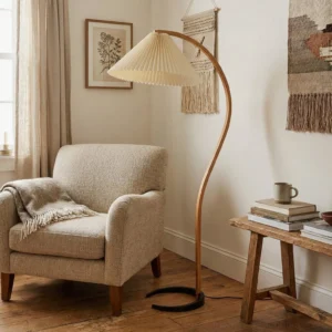 Caprani floor lamp in cozy living room interior, beside neutral linen armchair with wooden side table