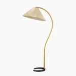Caprani mid-century modern floor lamp with curved beech wood stand and pleated linen shade, studio front view