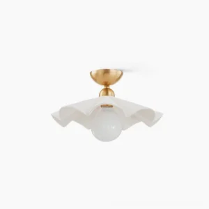 Capri ceramic flush mount ceiling lamp with polished brass base and white ruffled shade, studio product photography flat lay