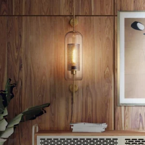 Elongated capsule glass wall lamp with warm brass mounting, side profile bedroom lighting