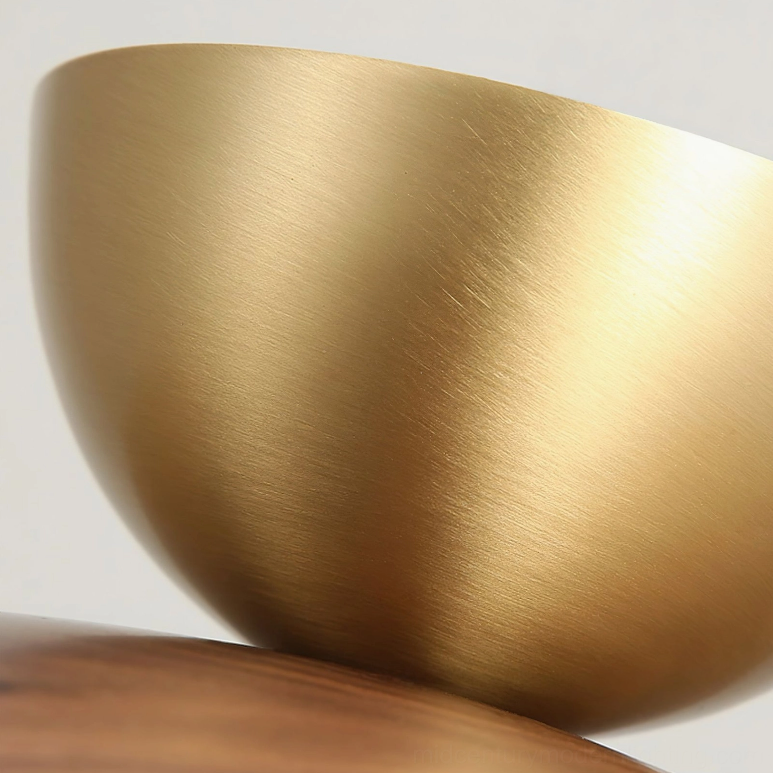 Extreme close-up of Carapace brass ceiling cap showing brushed metallic gold finish and curved surface craftsmanship