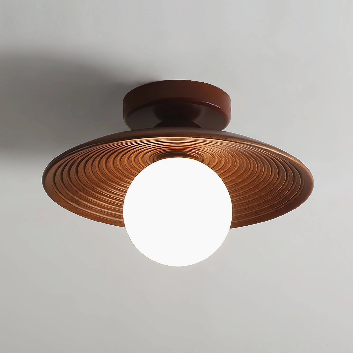 Three-quarter view of Carapace ceiling light with dark brown cap frosted white globe and sculptural ribbed design
