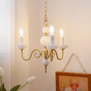Carlita 3-light brass chandelier hanging in cozy home interior with curtain and framed artwork