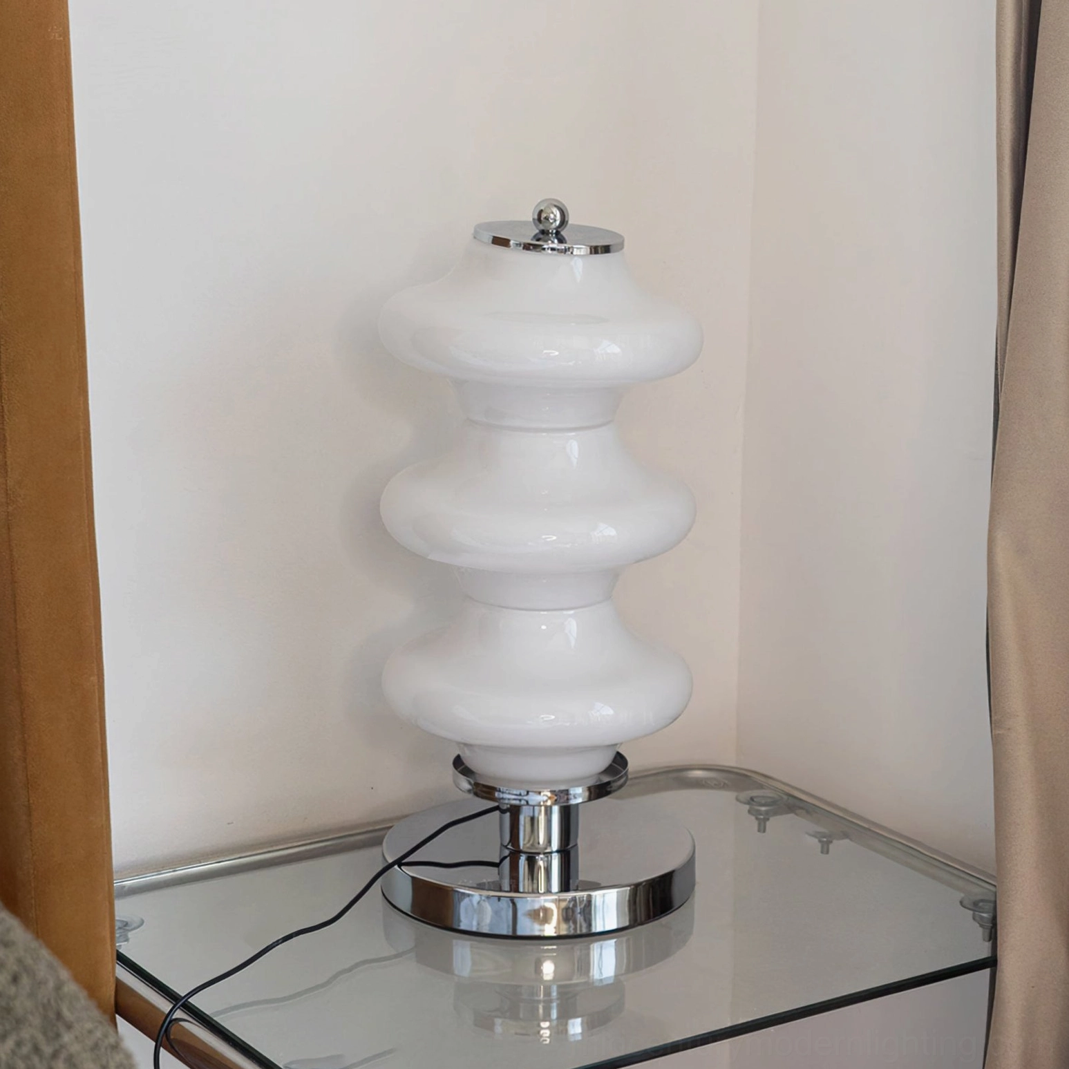 Carlo lamp base close-up detail showing polished chrome finish, chrome finial cap, and black power cord cable
