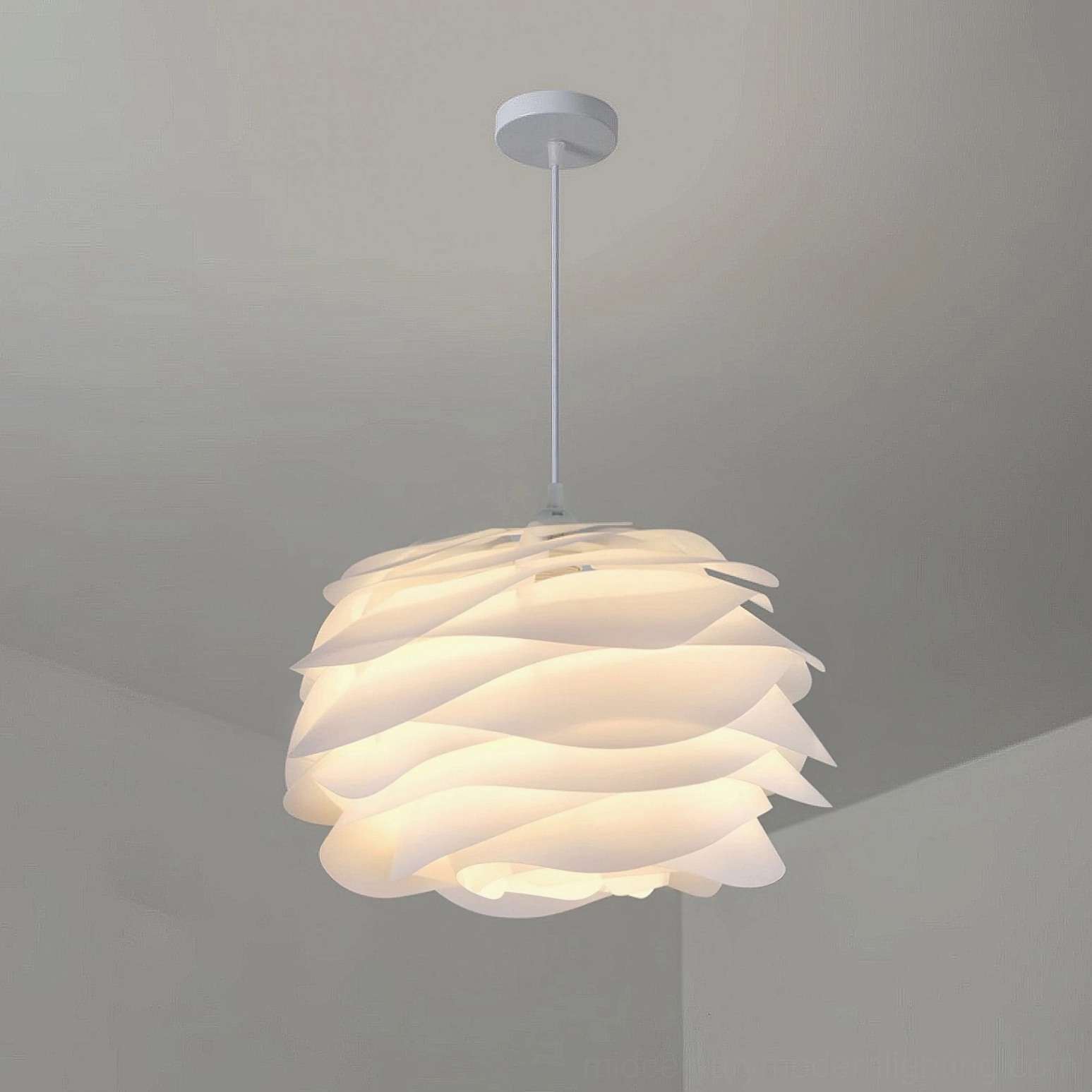 Carmina pendant lamp hanging from modern ceiling, warm glowing light through ruffled white acrylic shade