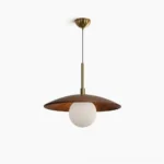 Caroll walnut and brass mid-century modern saucer pendant light with frosted white glass globe, front studio view