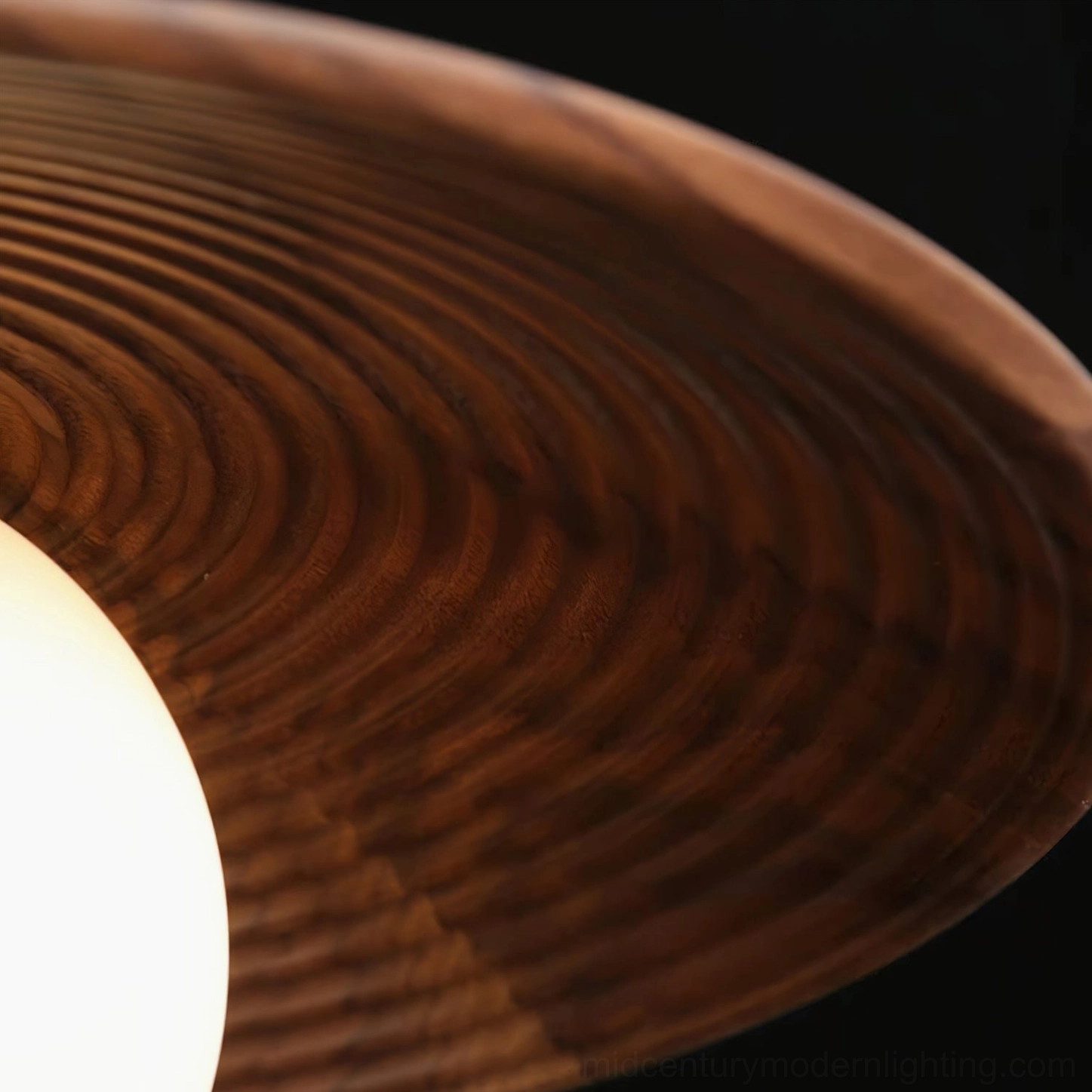 Caroll pendant light close-up of frosted white glass globe and brass mounting bracket