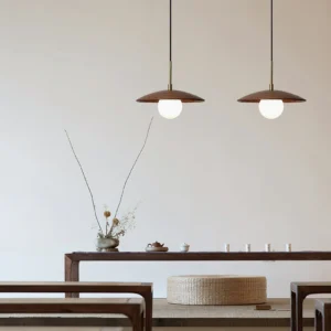 Two matching Caroll pendant lights suspended in minimalist oriental tea room with wooden furniture and neutral decor