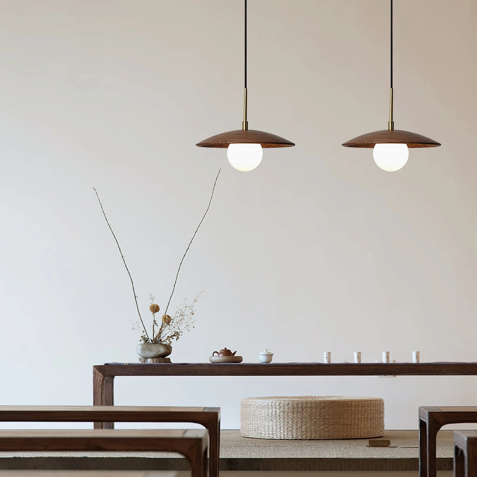 Two matching Caroll pendant lights suspended in minimalist oriental tea room with wooden furniture and neutral decor