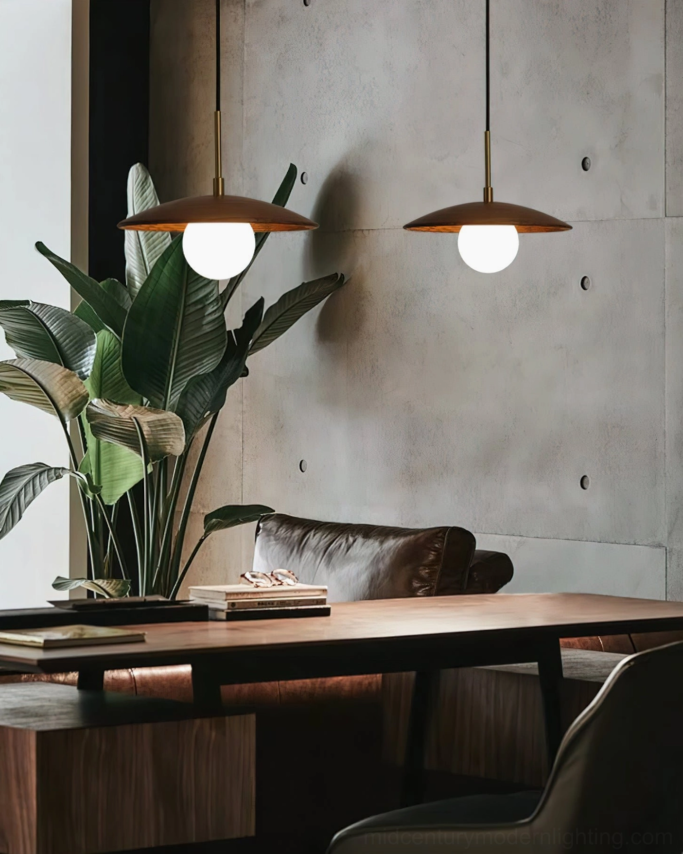 Two Caroll pendant lights in modern industrial living room with concrete wall and leather sofa