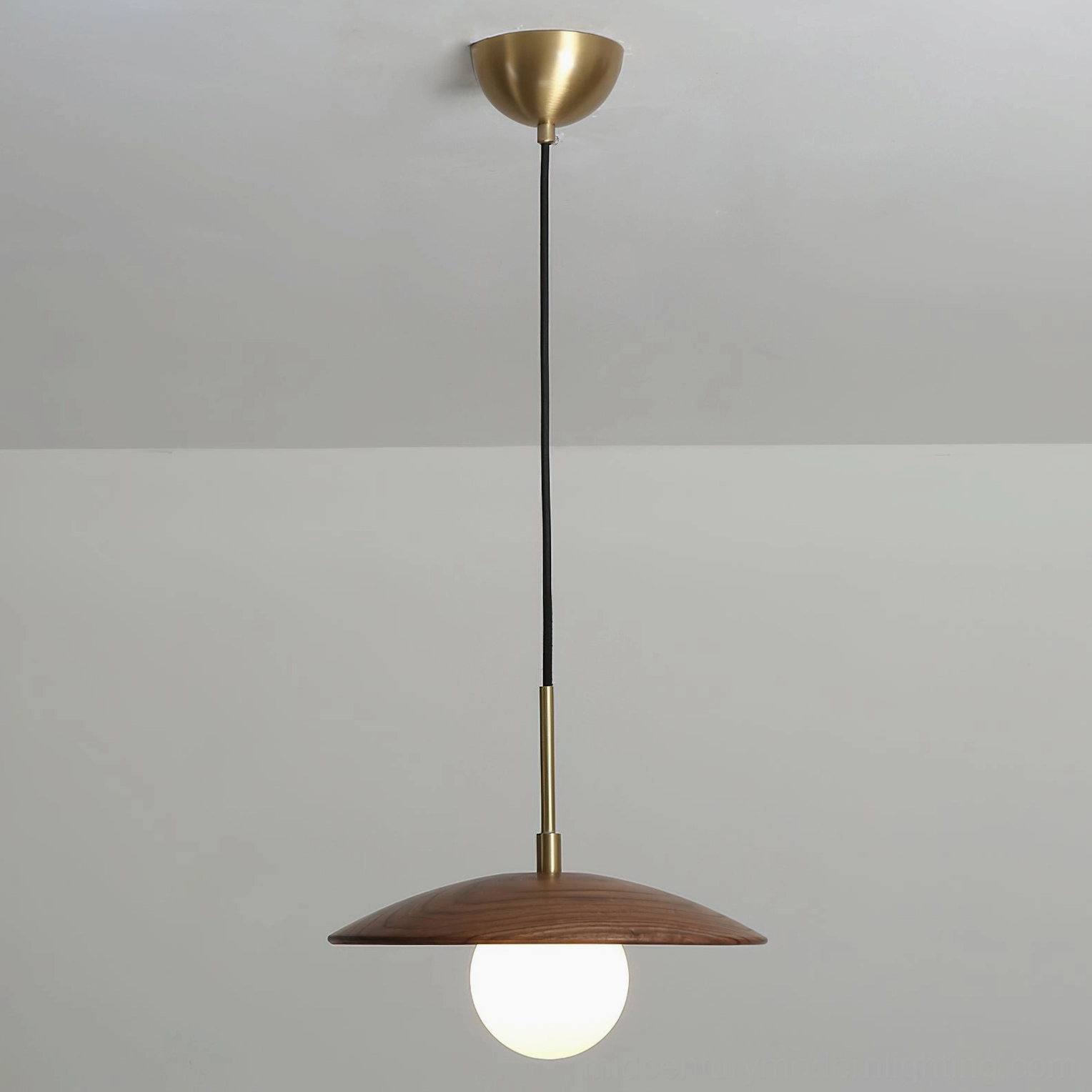 Caroll mid-century modern pendant light with walnut wood and brass in scaled interior setting