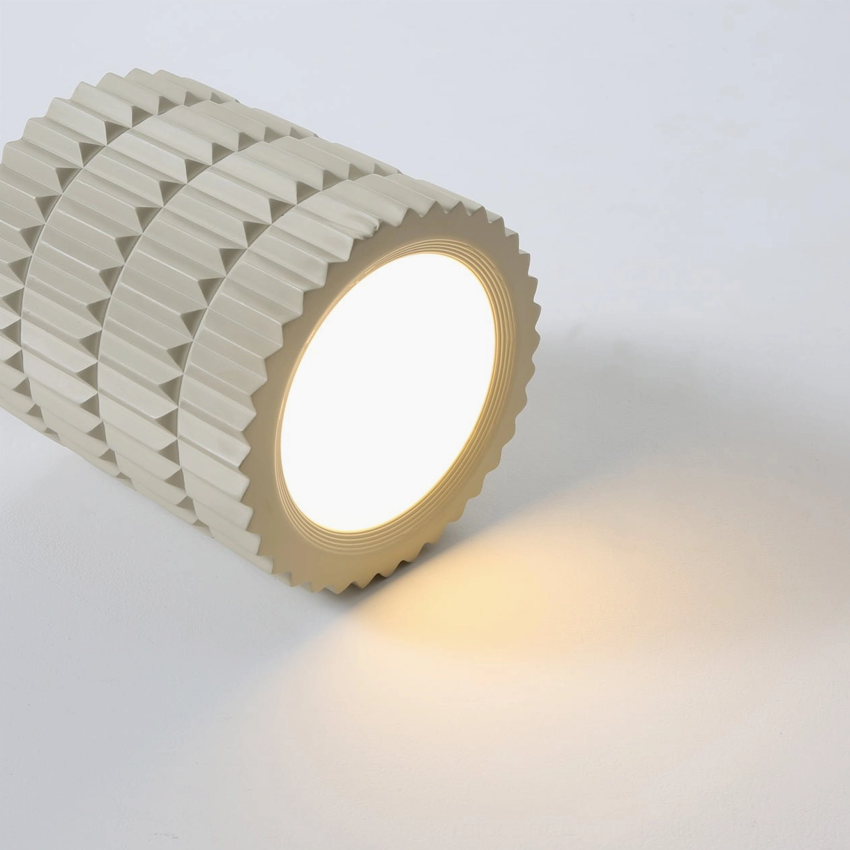Carran ribbed ceiling fixture oblique angle view, layered vertical flute texture with central glow panel