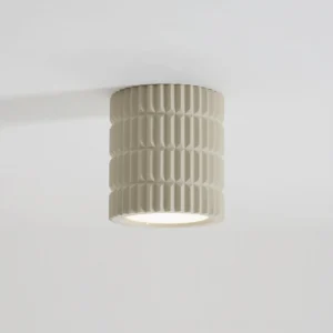 Modern Carran ceiling lamp mounted on white ceiling, emitting warm downlight in minimalist interior