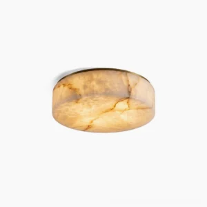 Carrara alabaster flush mount ceiling light with warm brass base, studio shot showing creamy marble texture and translucent stone details