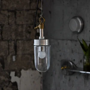 Carson Capsule Pendant Light hanging over exposed brick wall showing LED bulb and metal hanging fixture