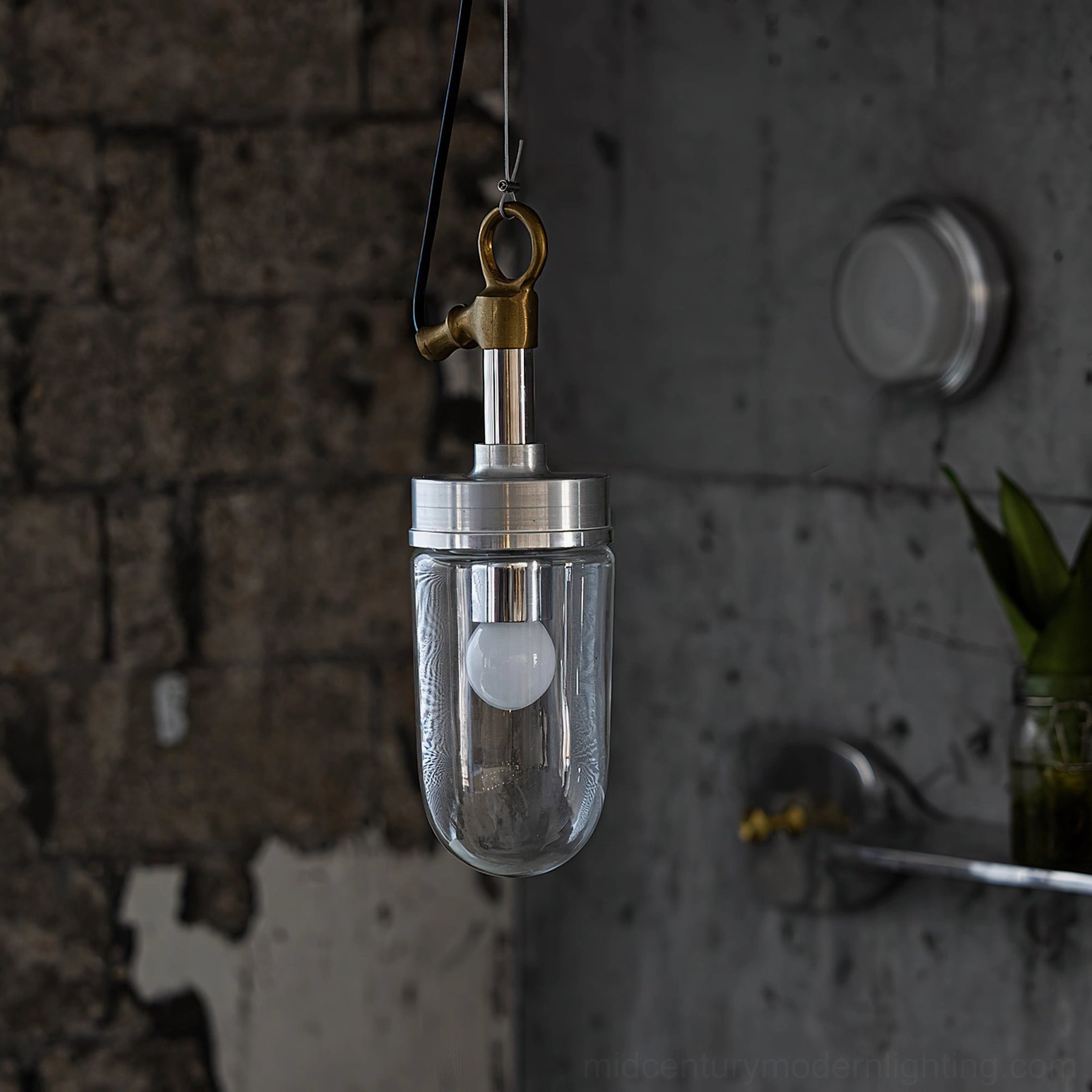 Carson Capsule Pendant Light hanging over exposed brick wall showing LED bulb and metal hanging fixture
