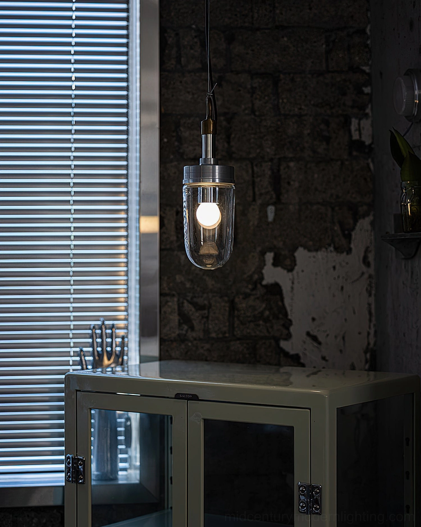 Illuminated Carson Capsule Pendant Light in industrial home space showing warm LED glow