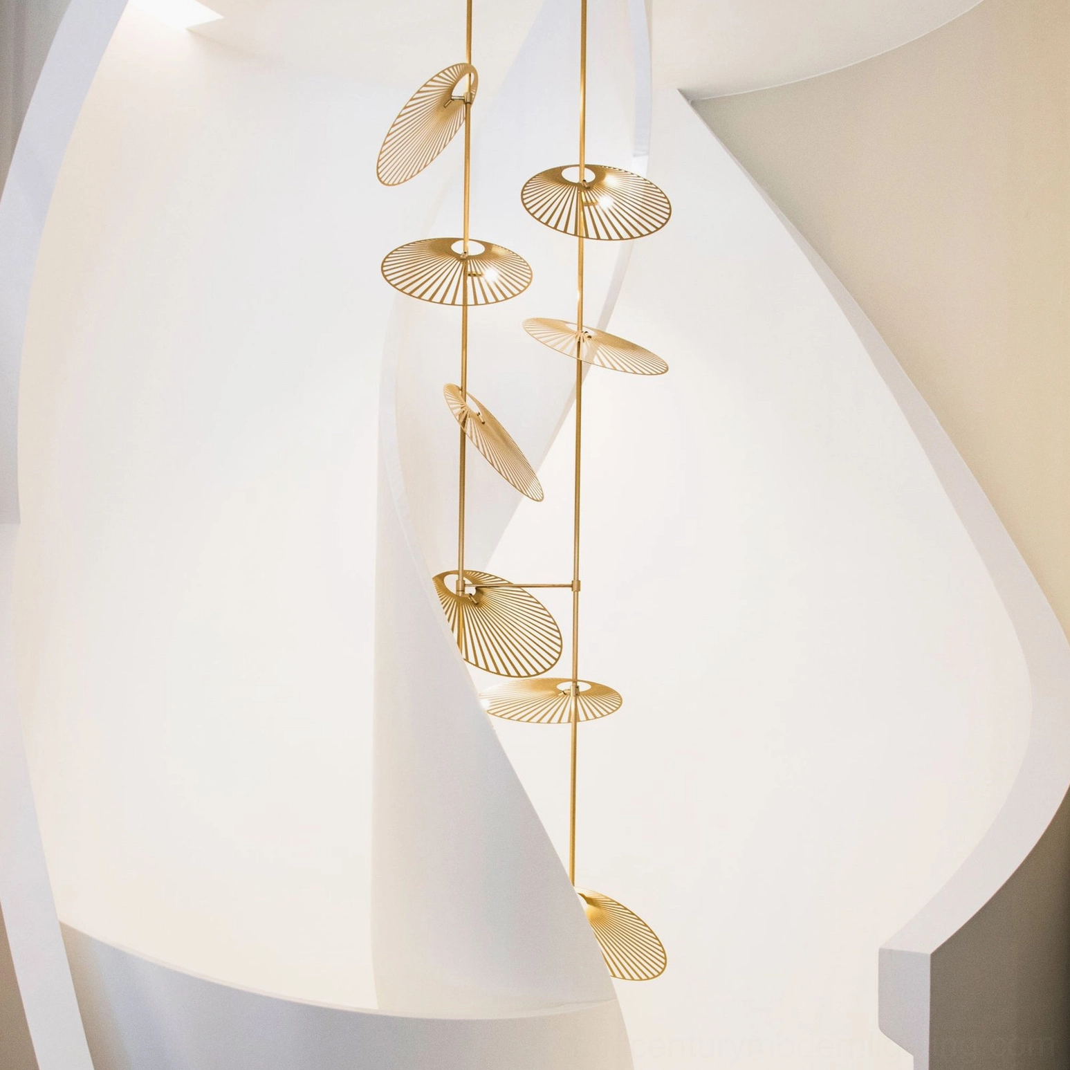 Slim linear cascade fan chandelier side profile in modern curved indoor corridor space