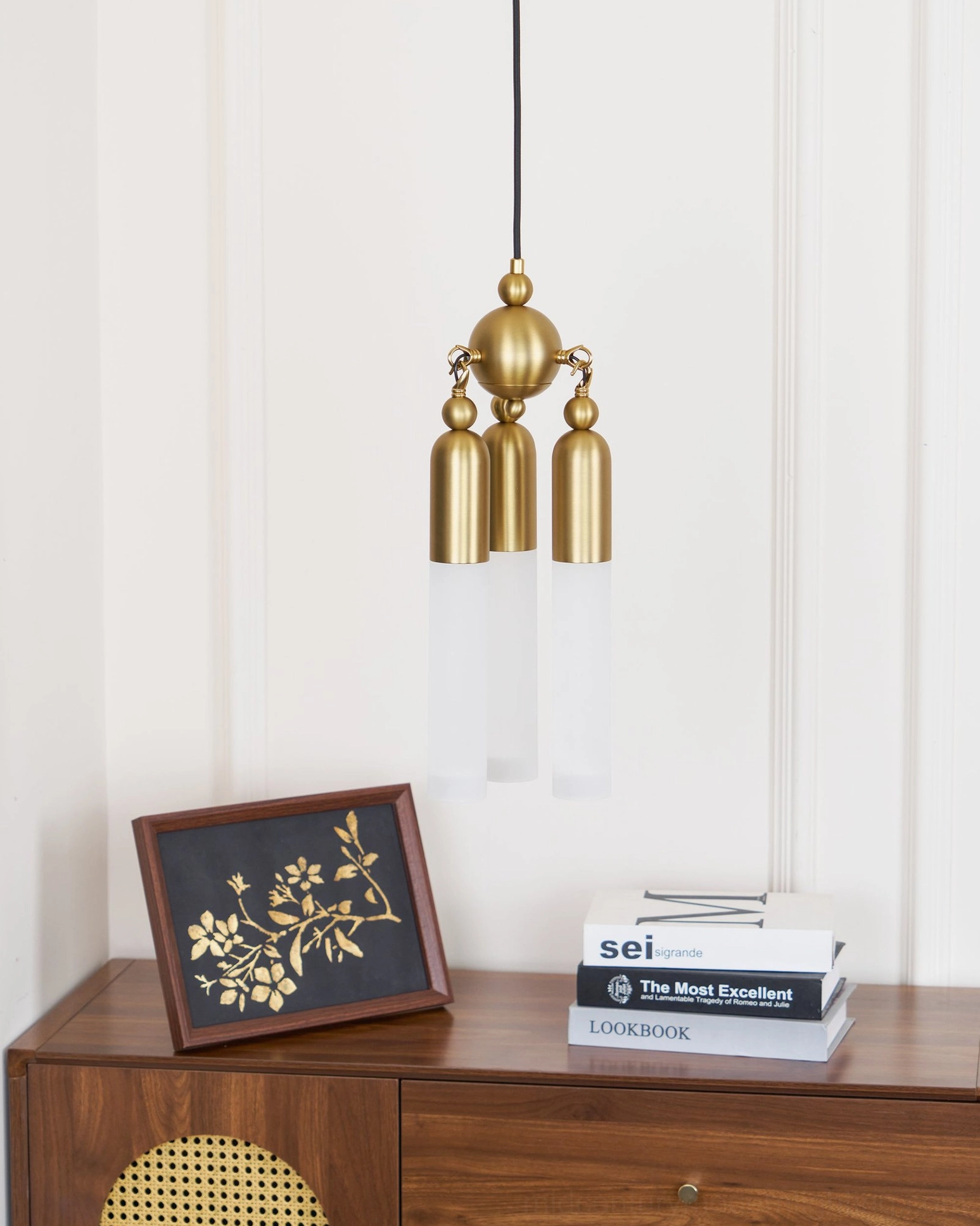 Cascadia mid-century modern pendant in minimalist interior, angled view showcasing brushed gold finish and clear frosted glass