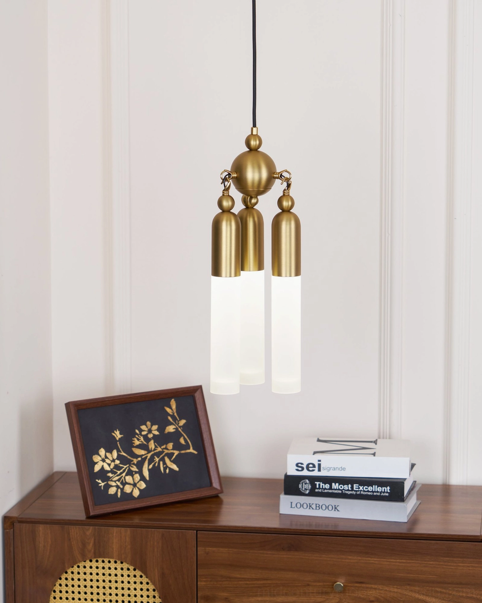 Cascadia three-light pendant displayed above wooden side table with home decor, three-quarter view showing sculptural design