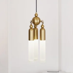 Close-up of Cascadia pendant light showing warm LED illumination through frosted acrylic shades and brass suspension hardware