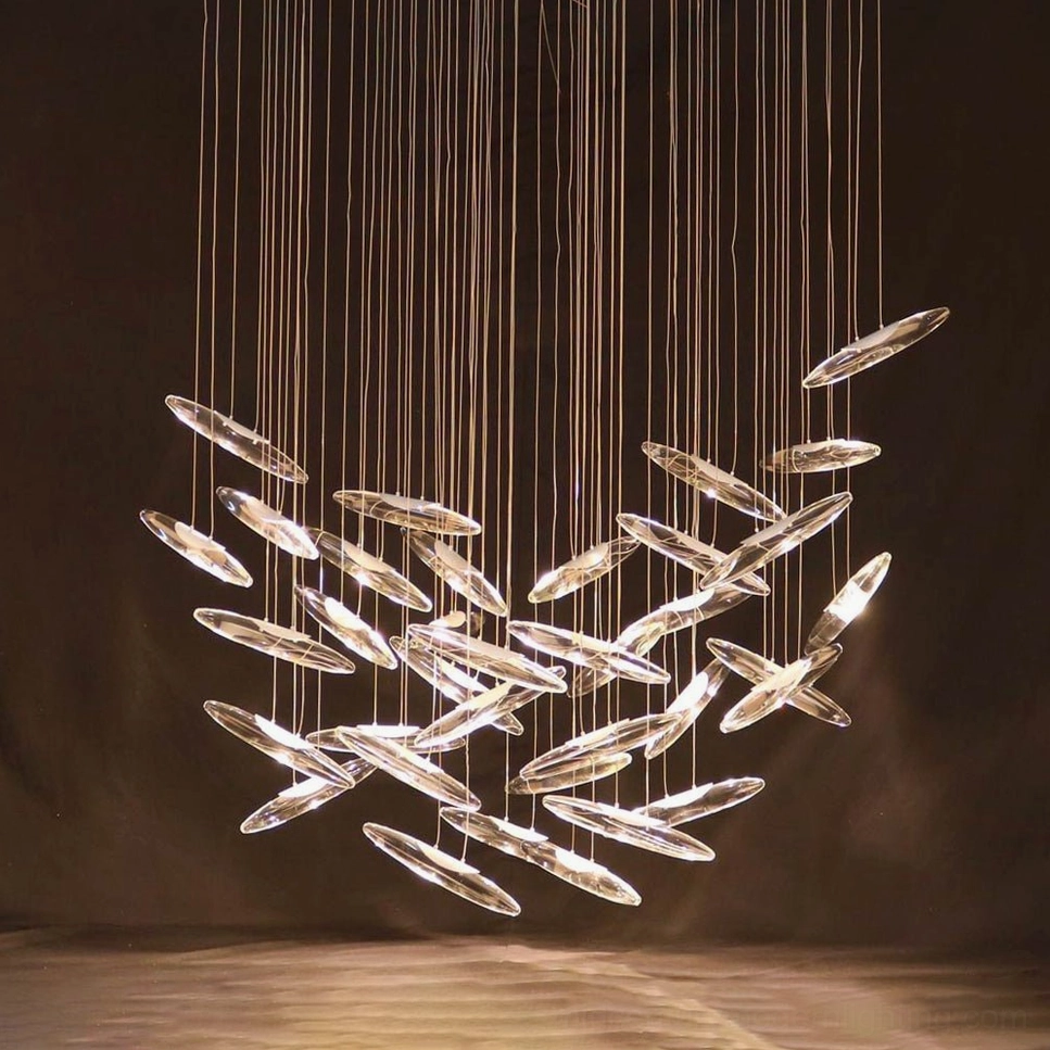 Cascading glass droplet chandelier with gradient clear pendants and warm underlighting in spiral configuration