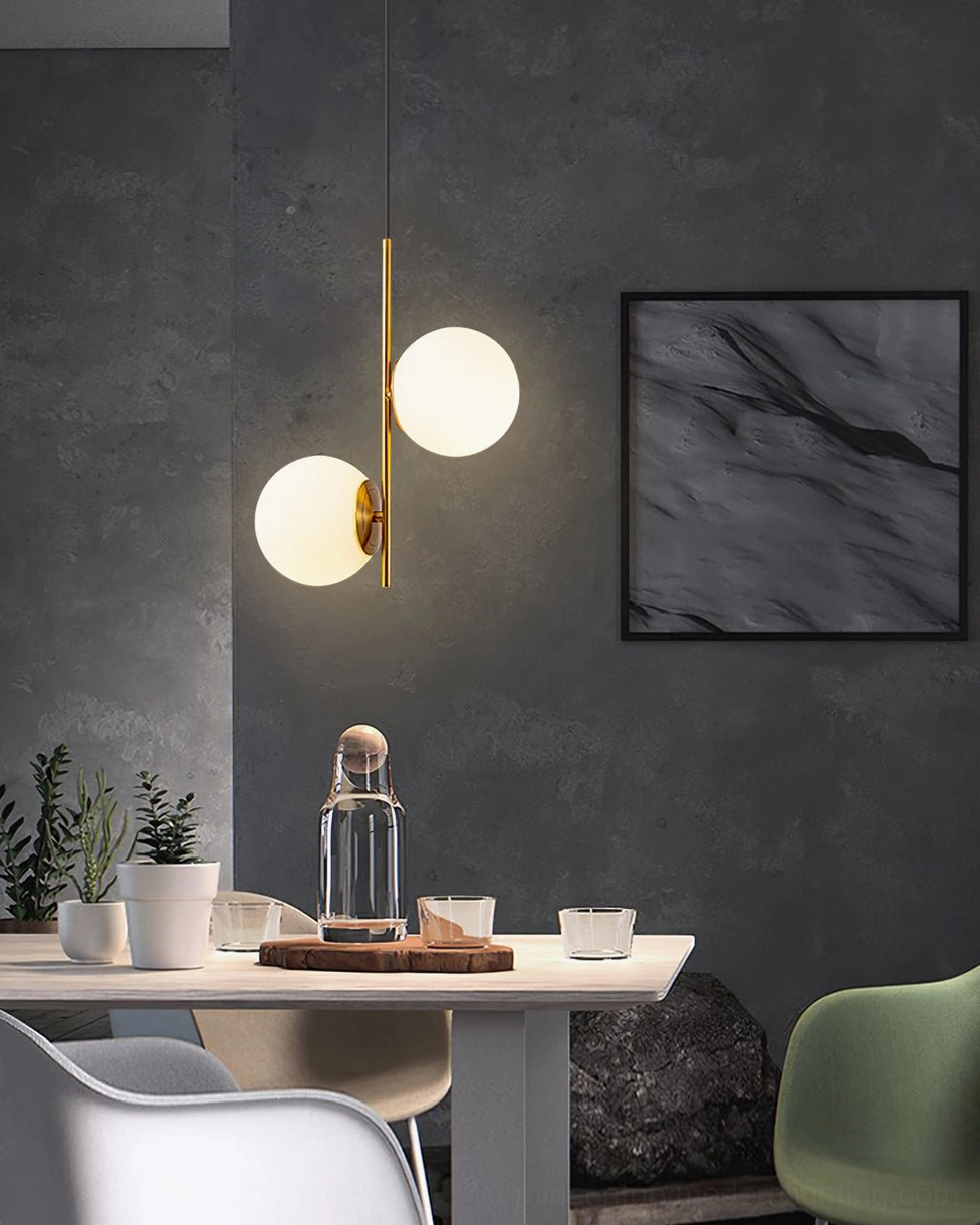Dual frosted glass globe pendant light by Castell displayed in modern dining area with wall art and tabletop styling