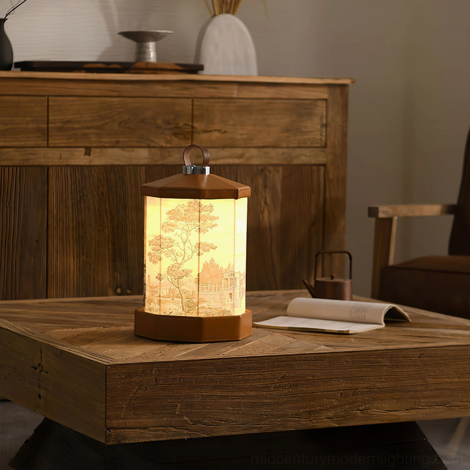Warm glowing Castle cordless LED table lamp on central coffee table with solid wood storage cabinet and unrolled paper scroll decor, showing ambient home lighting solution