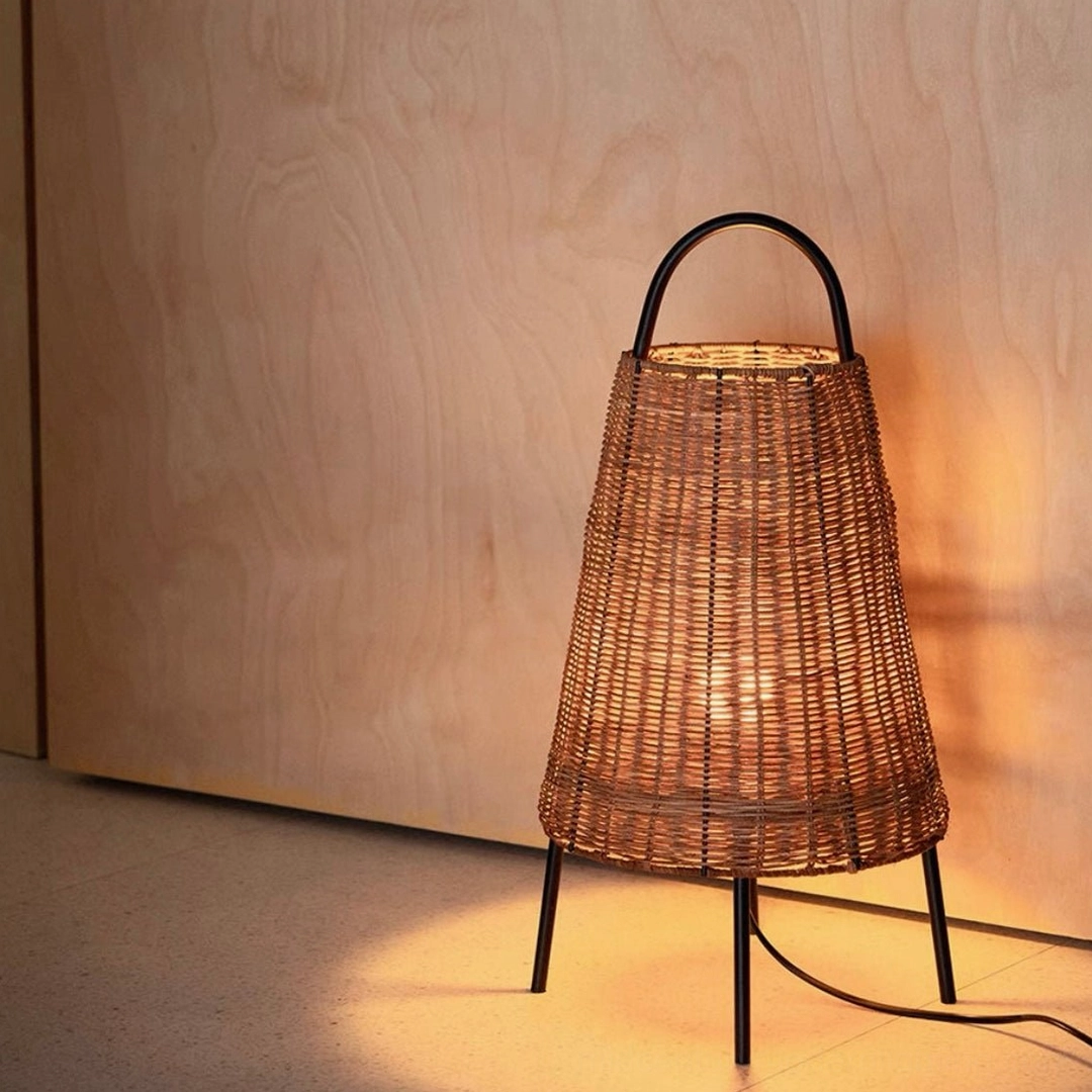 Catalina Coastal Table Lamp casting warm ambient light in modern minimalist wooden corner interior with visible power cord