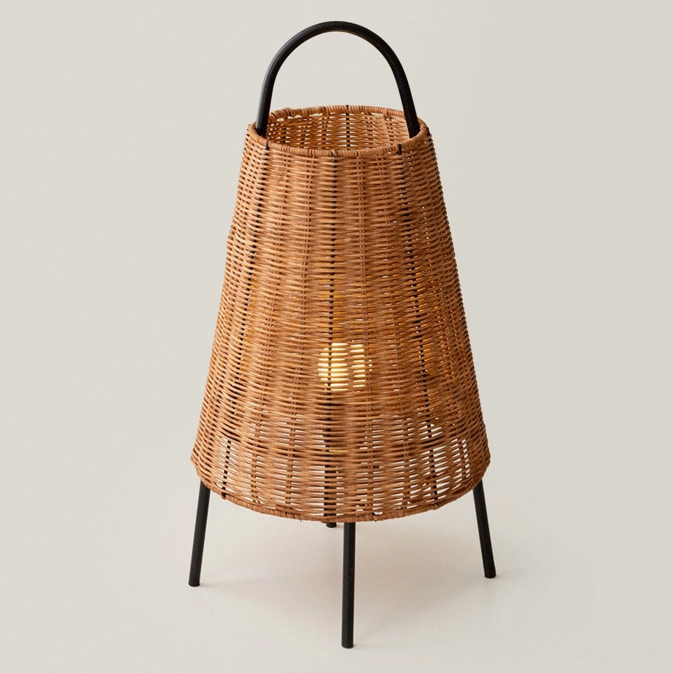 Catalina Coastal Table Lamp illuminated, showcasing woven rattan texture and dual light throw from base, studio white background
