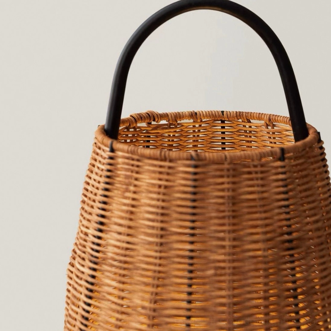 Overhead close-up of Catalina Coastal Table Lamp rattan shade top with curved black metal carry handle, detailed texture view