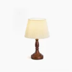 Catelyn mid-century modern table lamp with walnut wood base and pleated white fabric shade on pure white background