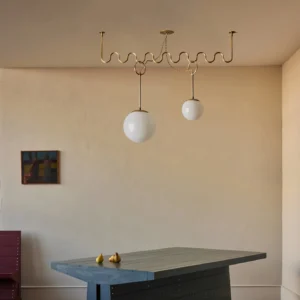 Two-head Cecil brass chandelier installed over minimalist dining table, mid-century modern interior lighting