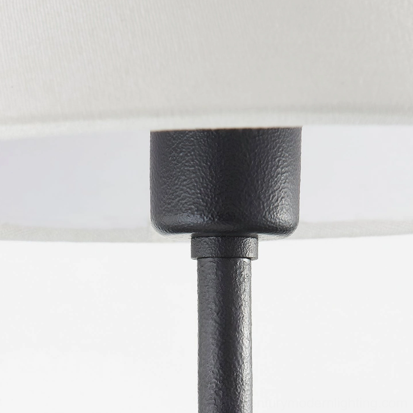 Close-up detail of cedar sconce textured matte black metal joint and articulation point, craftsmanship focus