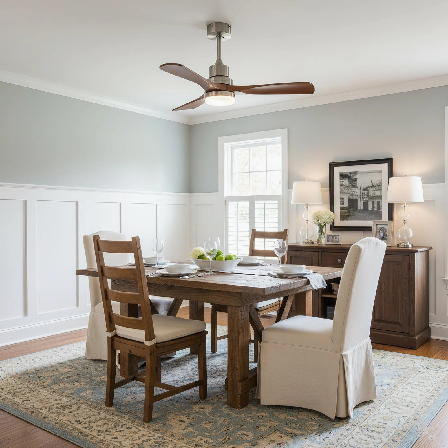 Contemporary ceiling fan light installed in classic dining room with white wainscoting, demonstrating warm LED illumination over wooden dining set