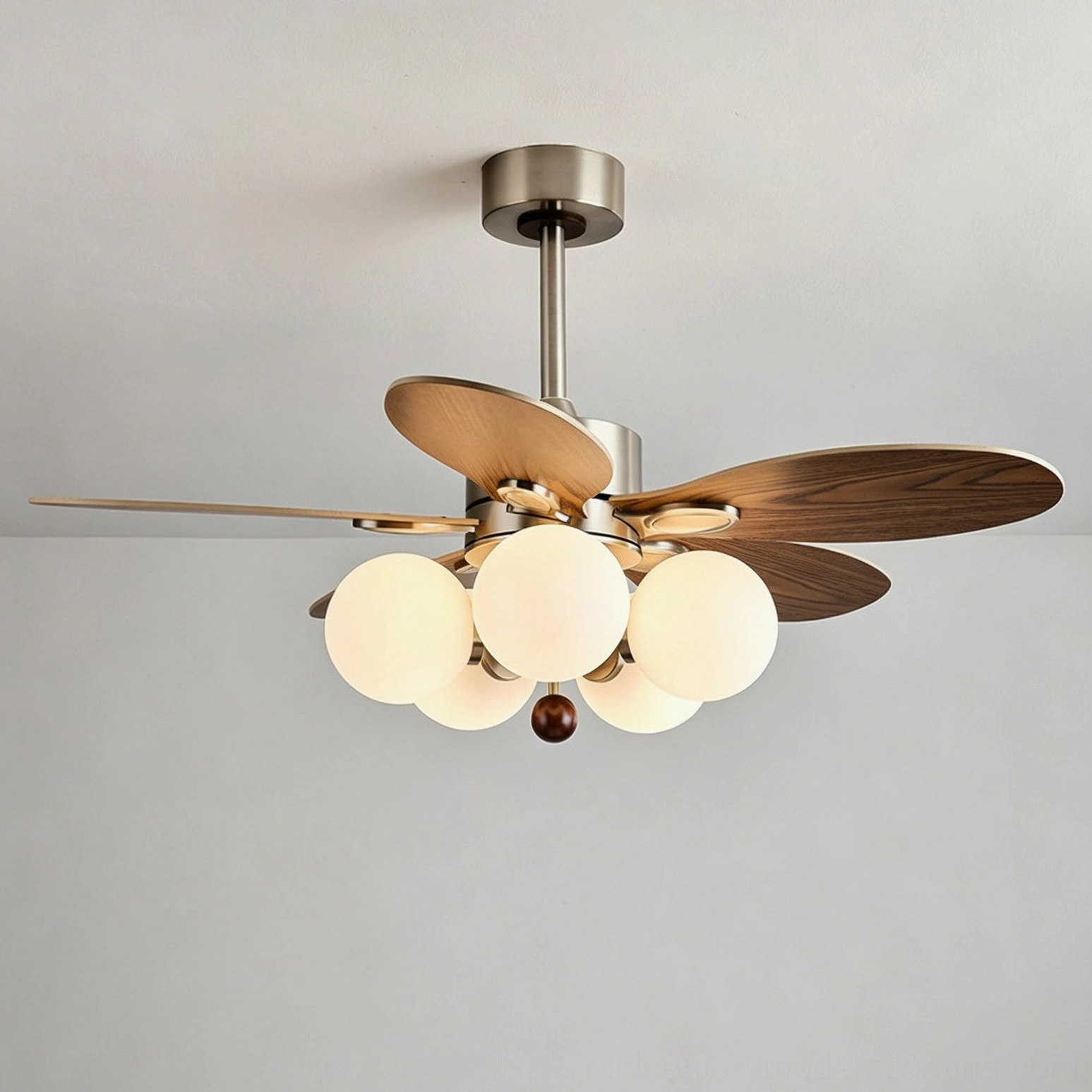 Low-angle view of ceiling fan light hardware and mounting system showing brushed metal frame, wood blade attachment points, and engineering precision