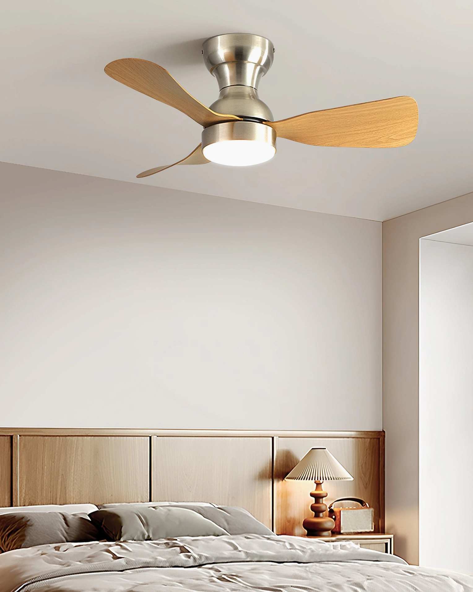 Master bedroom with wooden headboard and integrated LED ceiling fan light featuring light wood blades and brushed silver hardware in neutral bedroom setup