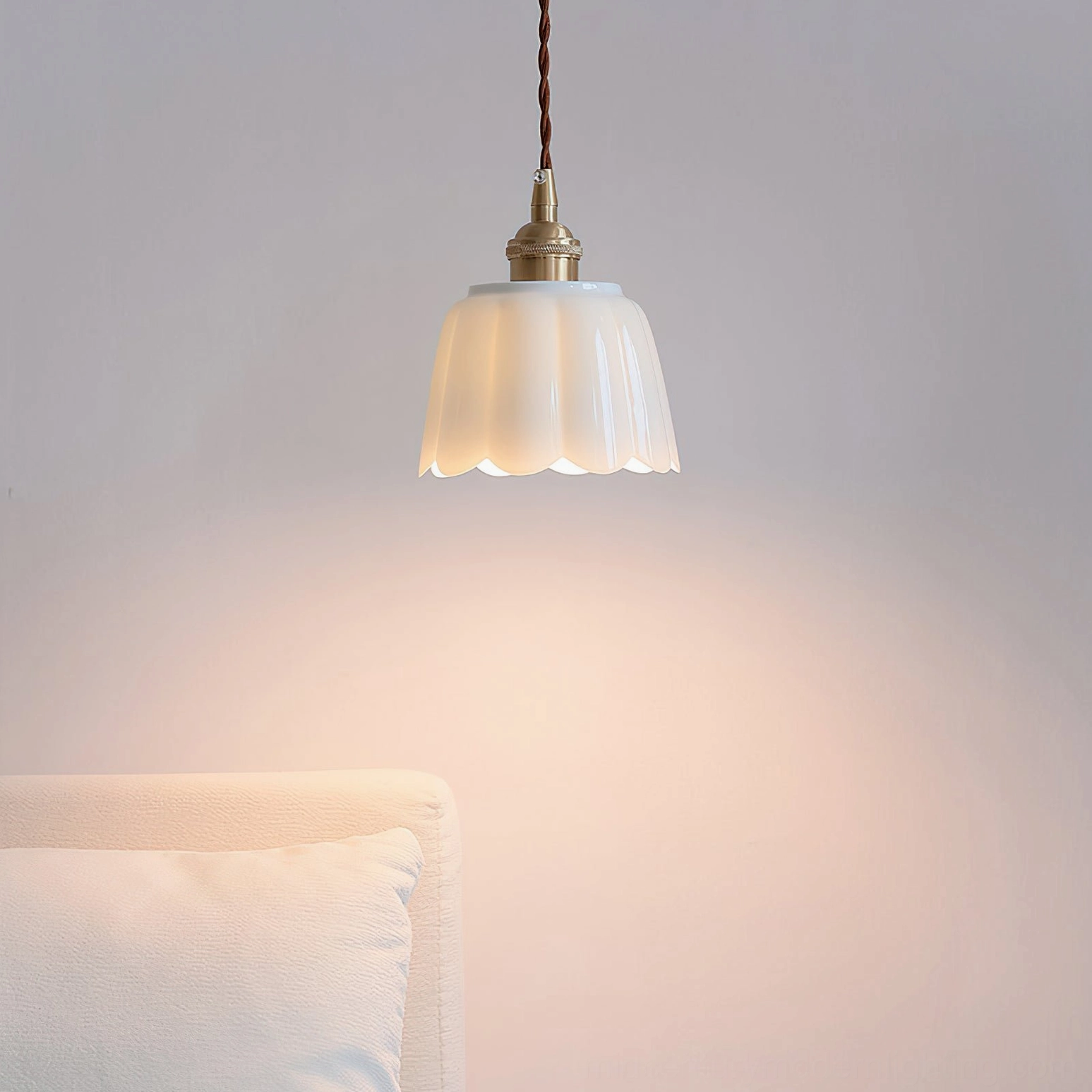Celadon ceramic pendant light suspended in bedroom creating soft warm ambient illumination