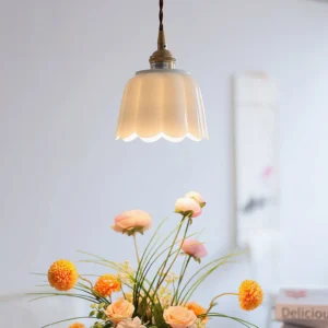 Celadon ceramic pendant light hung above warm nordic home décor with floral arrangement and natural lighting