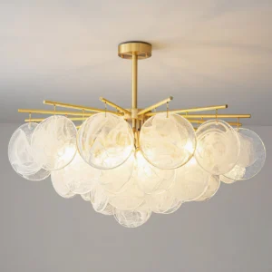 Celestia chandelier illuminated front view with warm light diffusing through layered glass discs mid-century modern brass frame