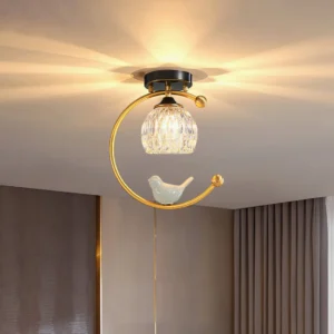 Ceramic bird flush mount ceiling fixture with sky-blue bird detail and warm light from below, close-up angle