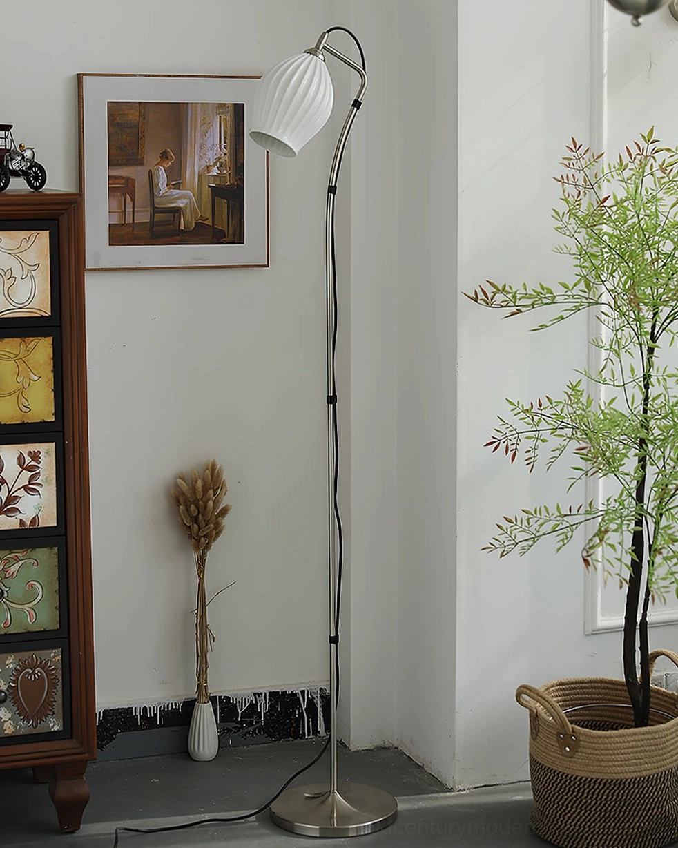Silver metal arc floor lamp with white ribbed ceramic shade in retro living room beside green plants