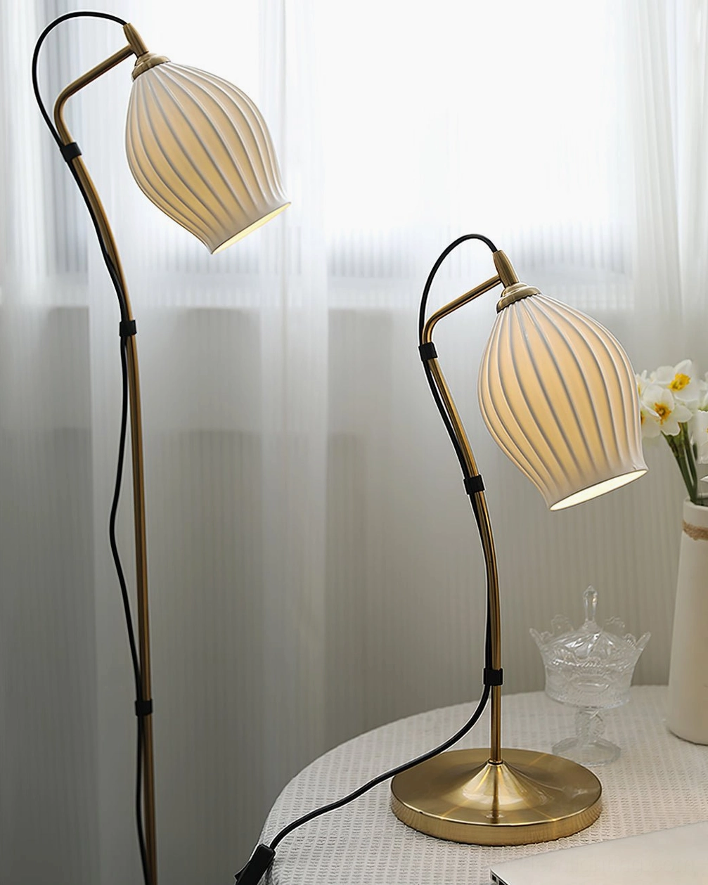 White ceramic ribbed shade arc floor lamp with elegant metal frame in contemporary home styling