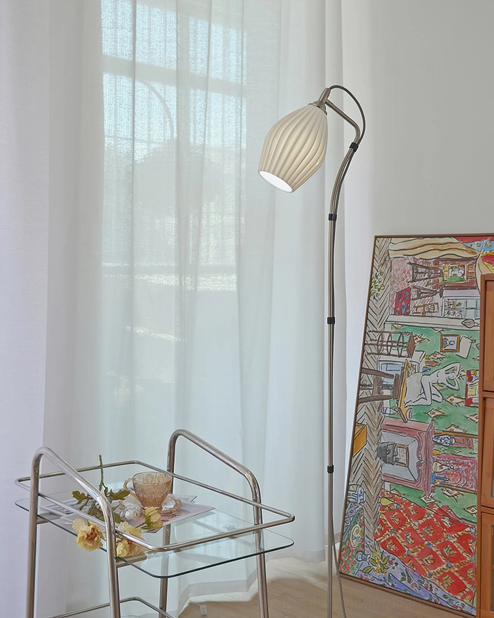 Ribbed ceramic arc floor lamp as accent lighting piece in Scandinavian minimalist interior design setting