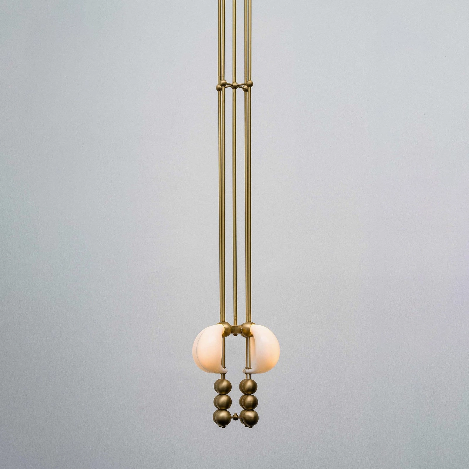 Champagne gold bent glass pendant chandelier with white opal shade - warm light overhead view modern luxury lighting