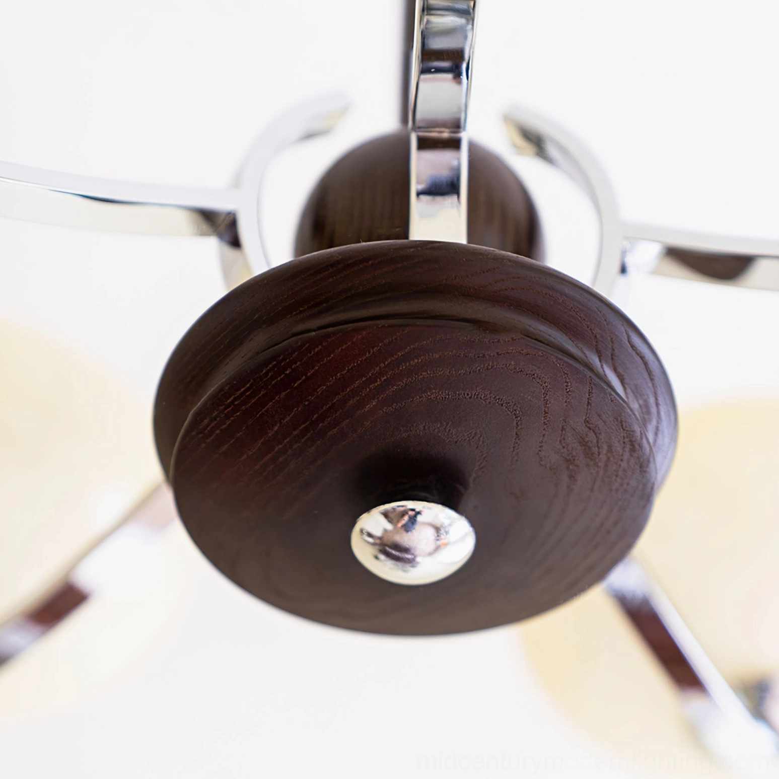 Macro top-down view of mid-century glass chandelier ceiling mount showing stained dark wood grain and polished chrome decorative hardware